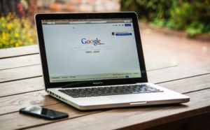 macbook pro on a table with google search open