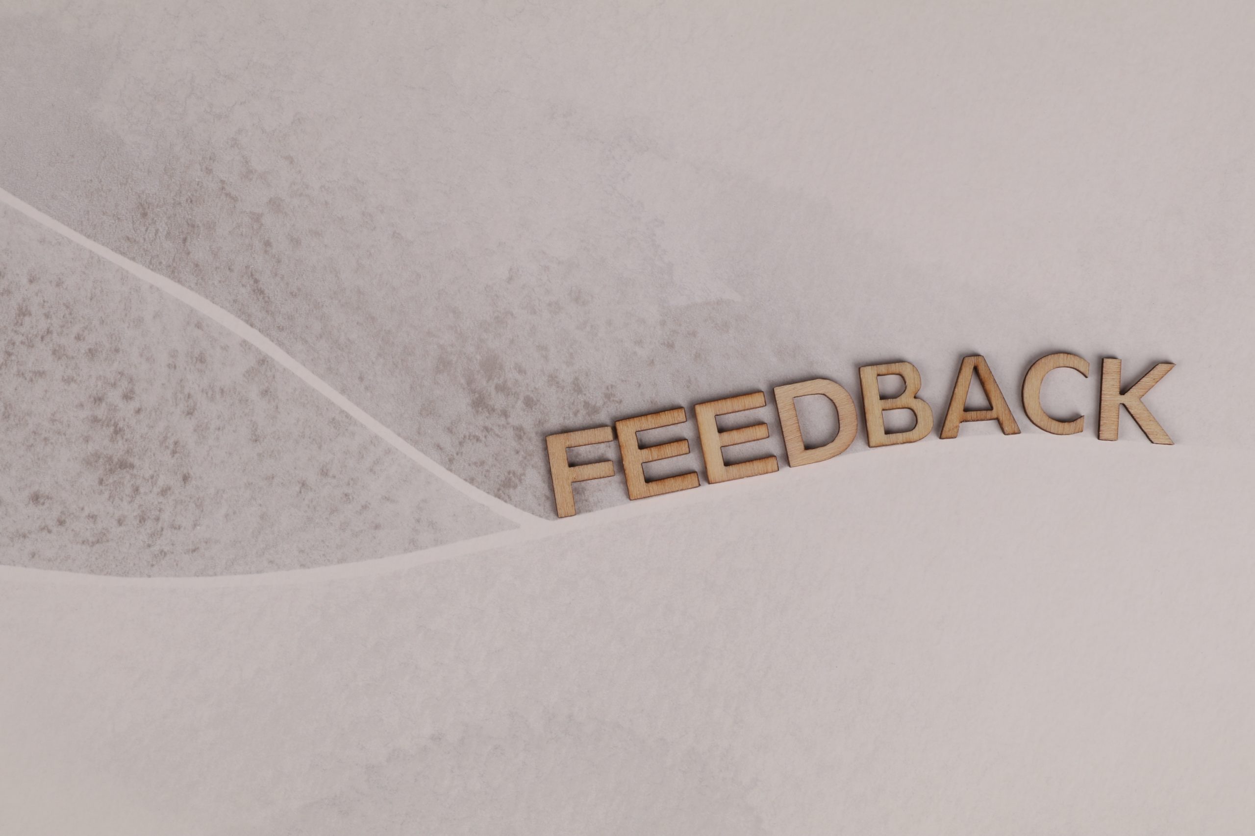 the words 'feedback' on a sandy textured background